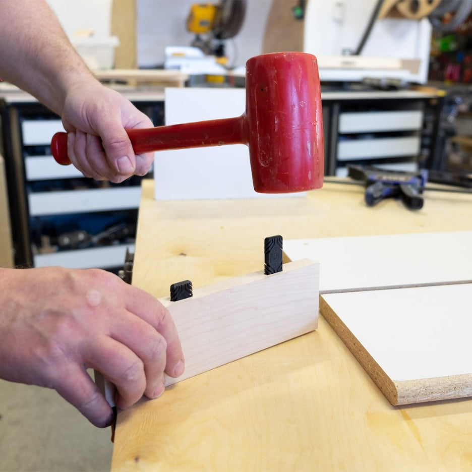 Hand holding mallet and wood with Fastcap Fastenon