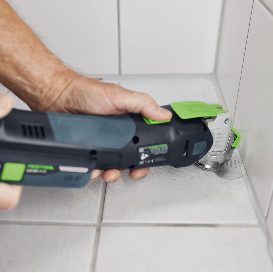 Hand holding Festool OSC 18 with Festool Silicone Blade 